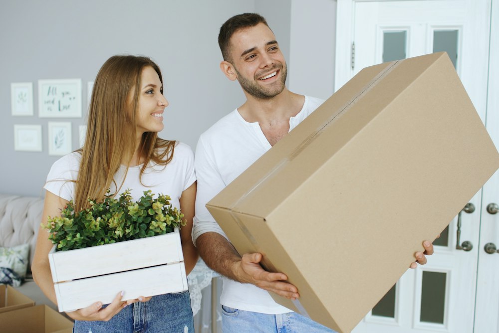 Couple carrying moving boxes into their new home